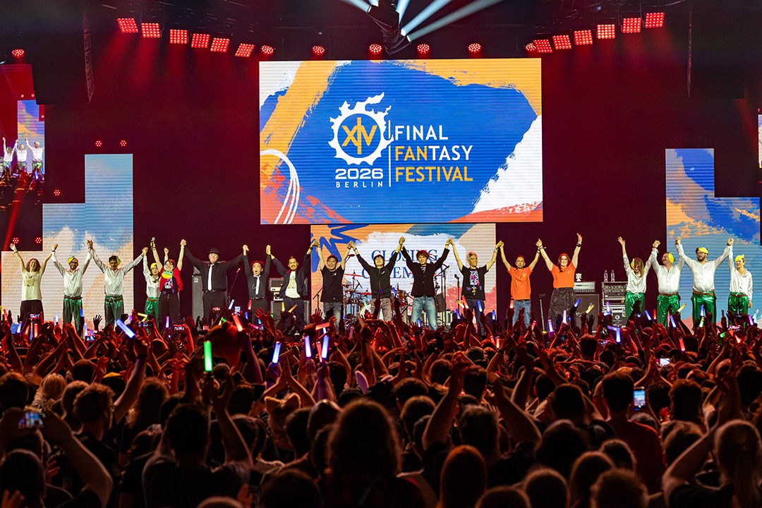 The closing ceremony at Fan Festival 2026 in Berlin. Square Enix developers and staff members are holding up their arms with their hands linked on stage in front of a huge crowd.