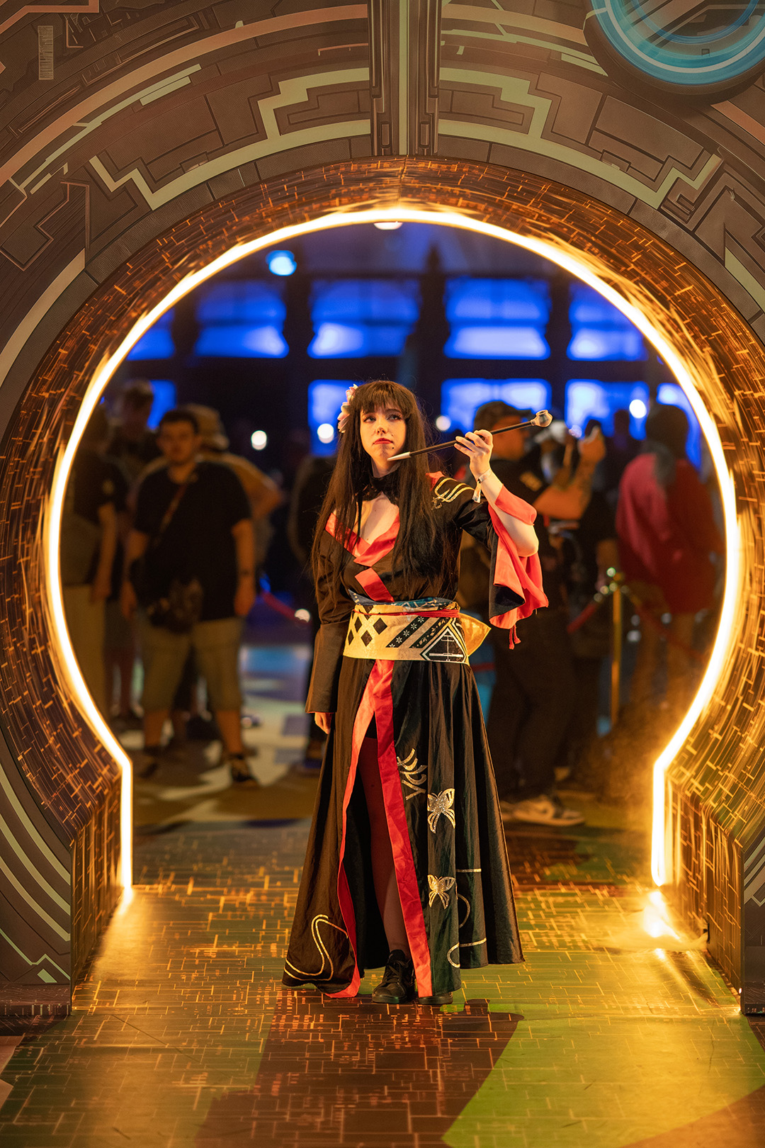 A Fan Festival 2026 in Berlin attendee in a Yotsuyu cosplay poses underneath the gate to the golden city themed photo spot.
