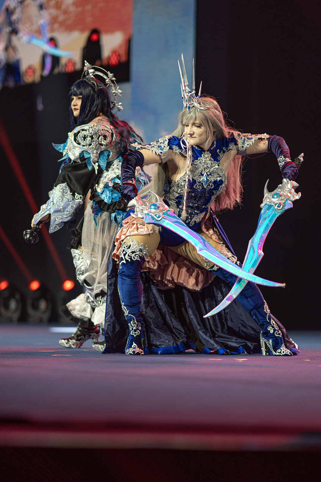Two players dressed as Gaia and Ryne on stage for the Glamoured to Life cosplay walk at Fan Festival 2026 in Berlin.