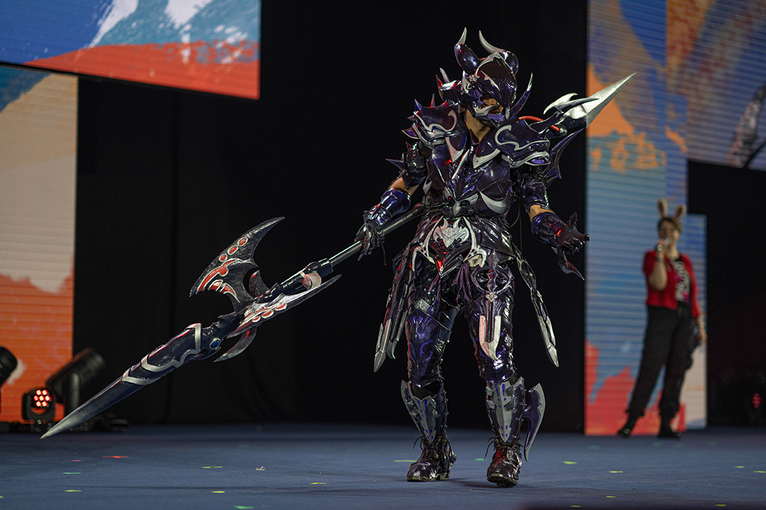 A fully armored dragoon on stage for the Glamoured to Life cosplay walk at Fan Festival 2026 in Berlin.