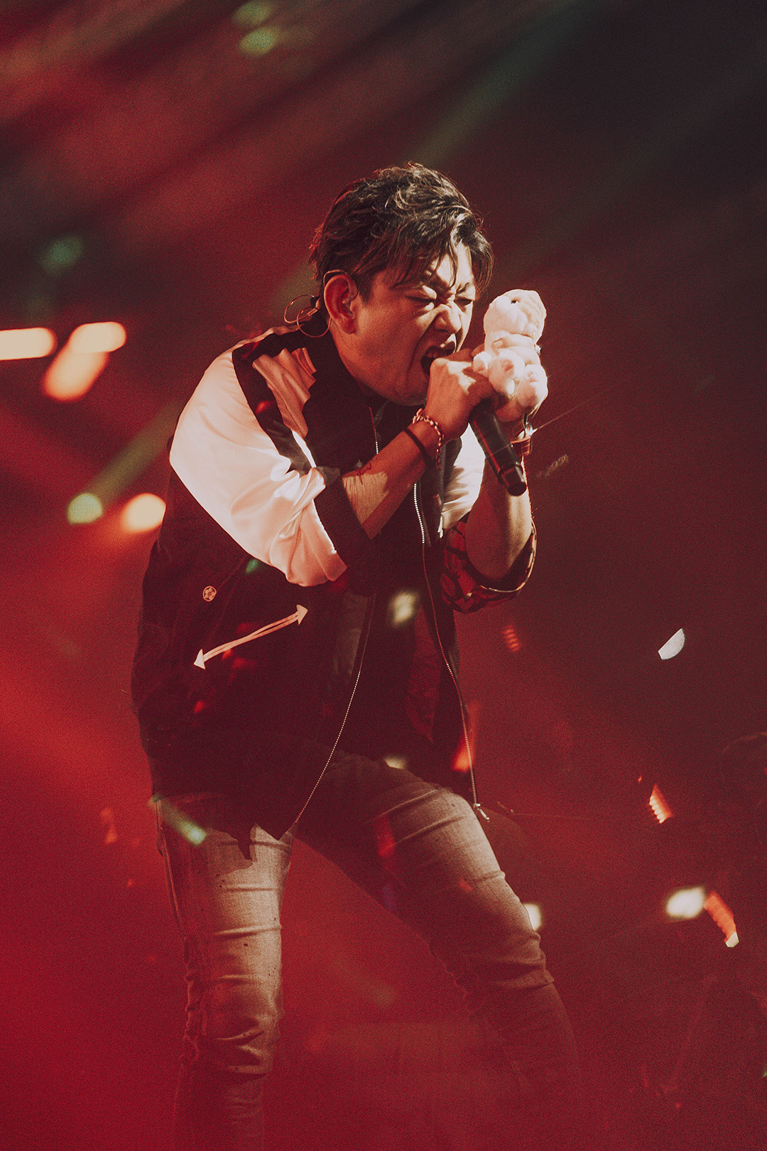 Naoki Yoshida holding a cat plush and yelling into a microphone while performing on stage at Fan Festival 2026 in Berlin.