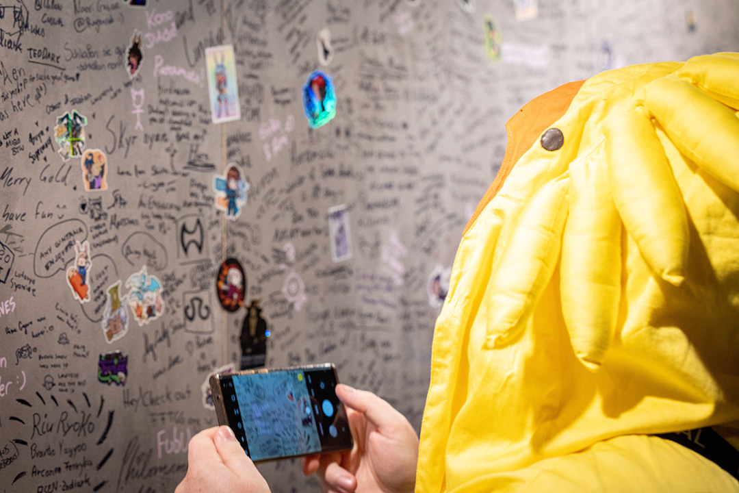A close up of a Fan Festival 2026 in Berlin attendee taking a picture of the event's signing wall with their smartphone.
