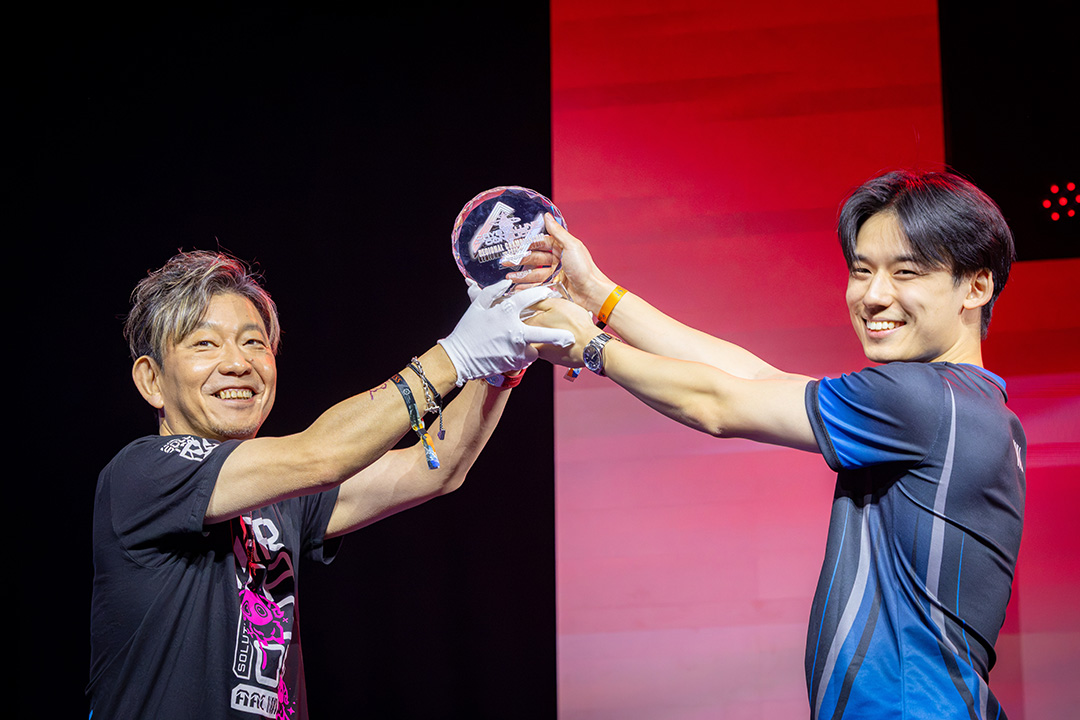Final Fantasy 14 Producer and Director Naoki Yoshida handing over a trophy to the team captain of the Crystalline Conflict Regional Championship 2026 Europe and Oceania winners.